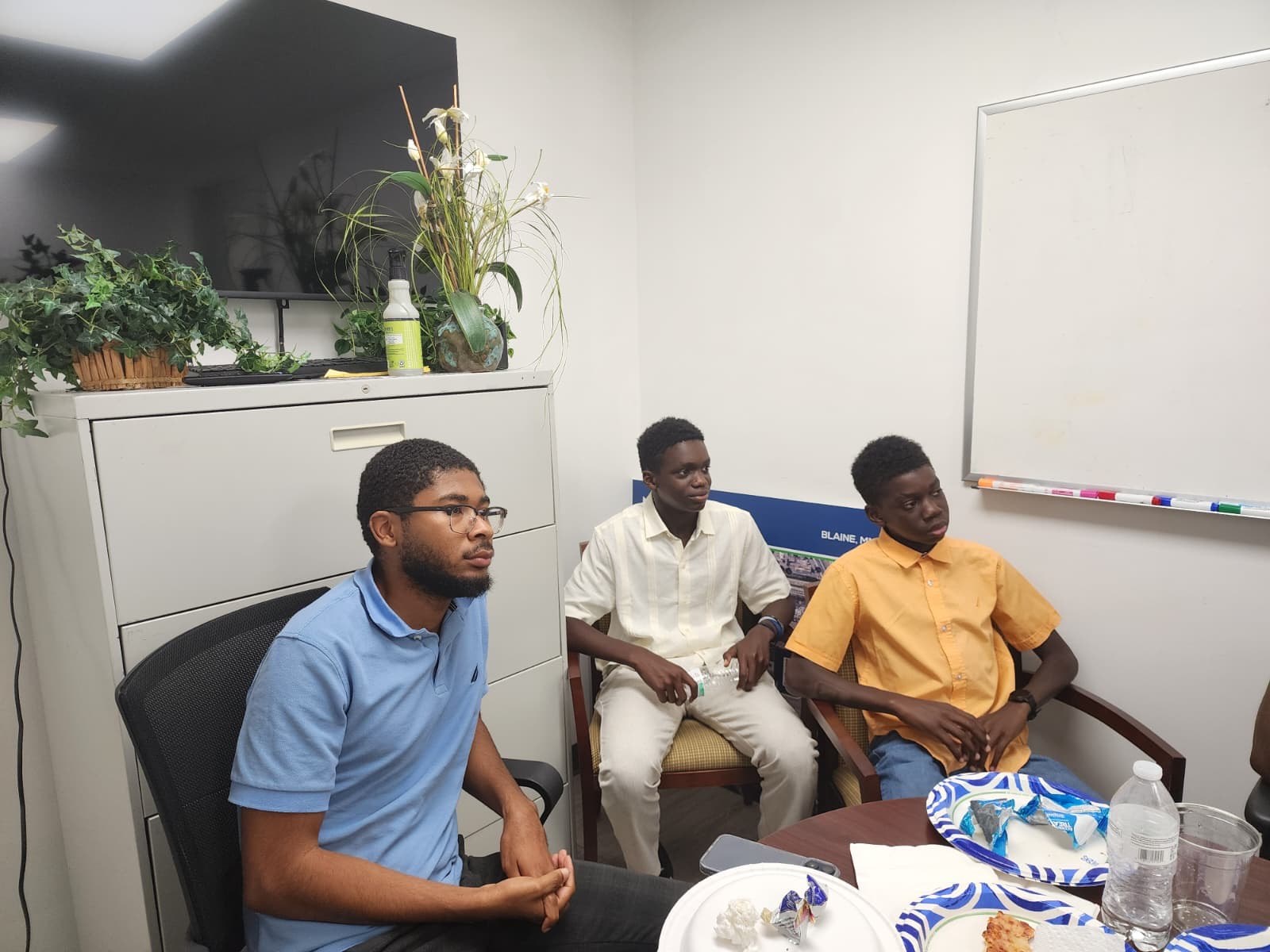 Three young men listening attentively during the fireside conversation