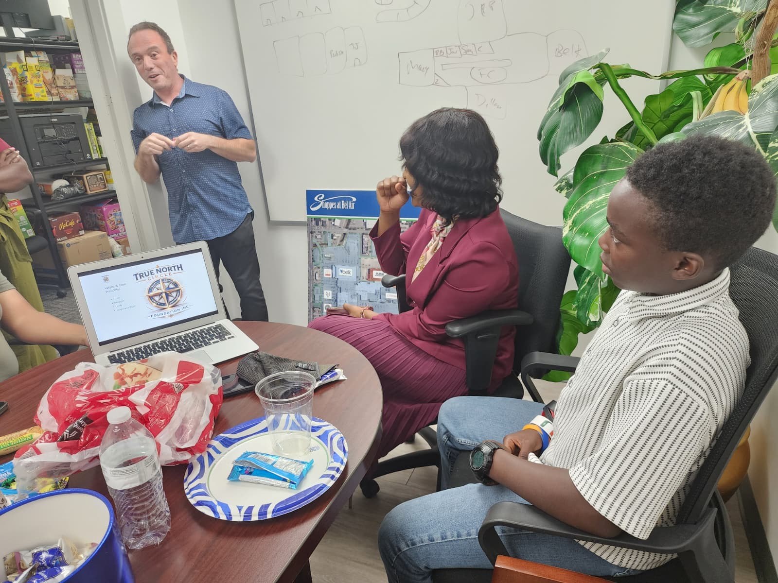 Felix Reznick speaking to the group beside a laptop showing the True North Circle values slide