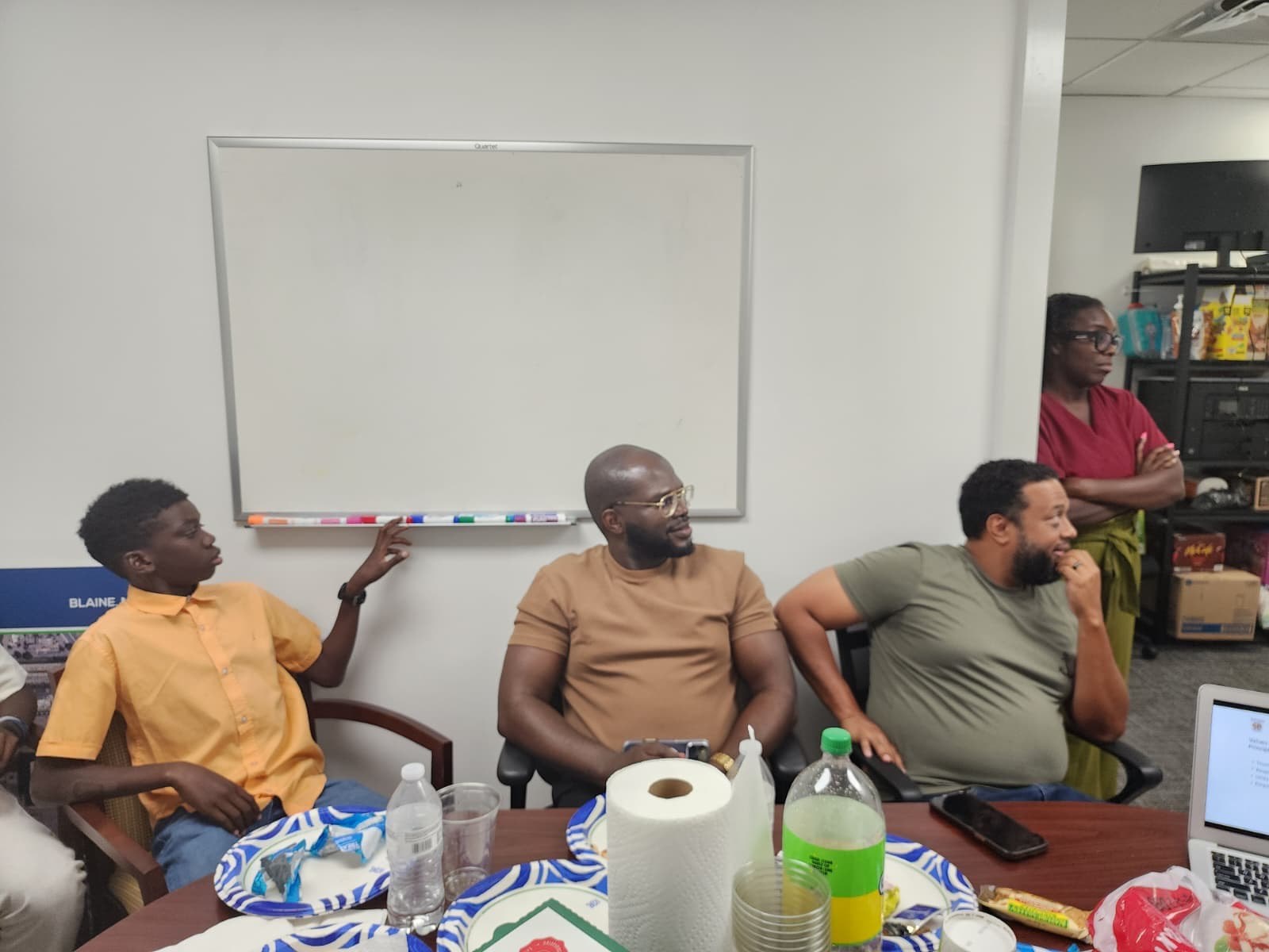 Mentors and a young man engaged in the conversation at the fireside