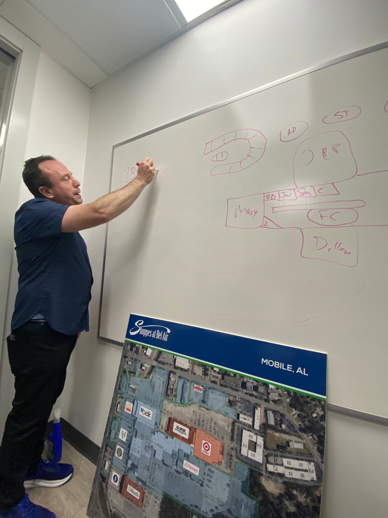 Felix Reznick diagramming a shopping center layout on a whiteboard